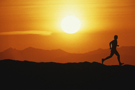Läufer in den Bergen vor Sonnenuntergang